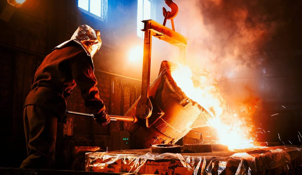 An overhead crane rail in use at a steel mill to lift heavy cauldron